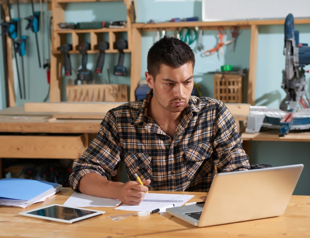 Artisan devant son ordinateur, en train de faire du travail administratif.