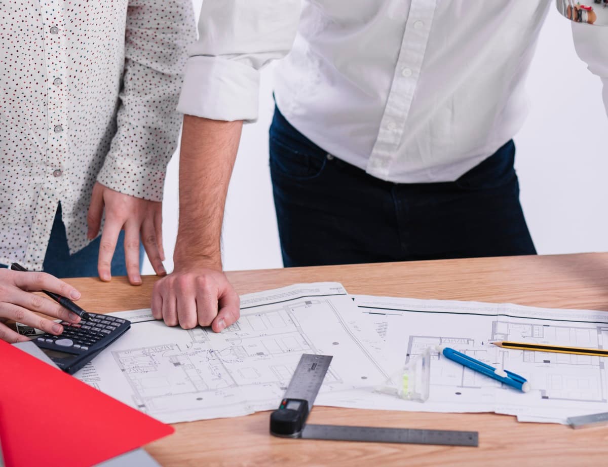 deux personnes travaillant sur des plans