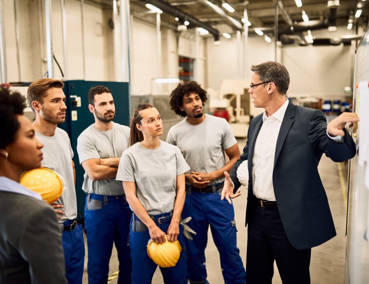 Groupe de travailleurs écoutant une présentation dans une industrie