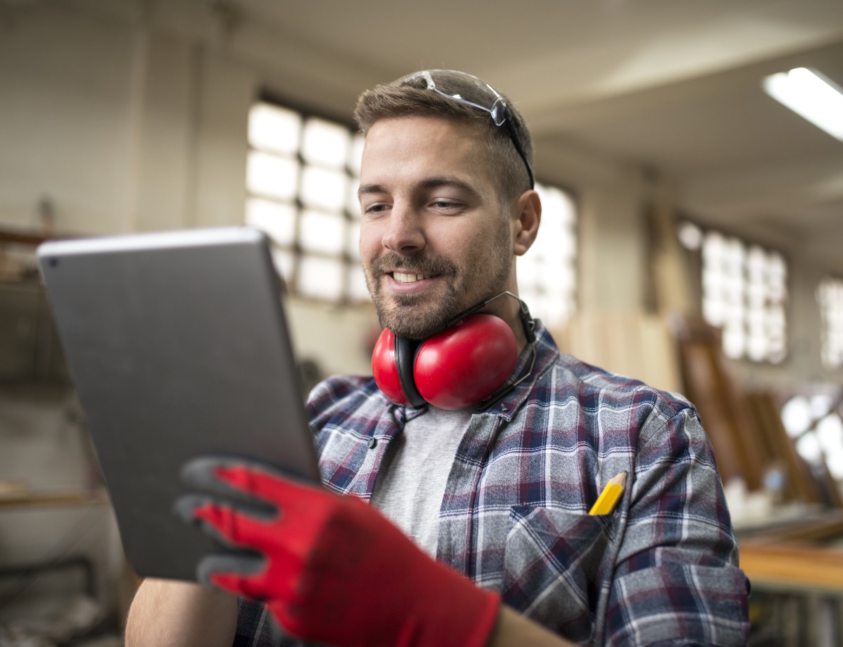 Charpentier en train de travailler sur une tablette