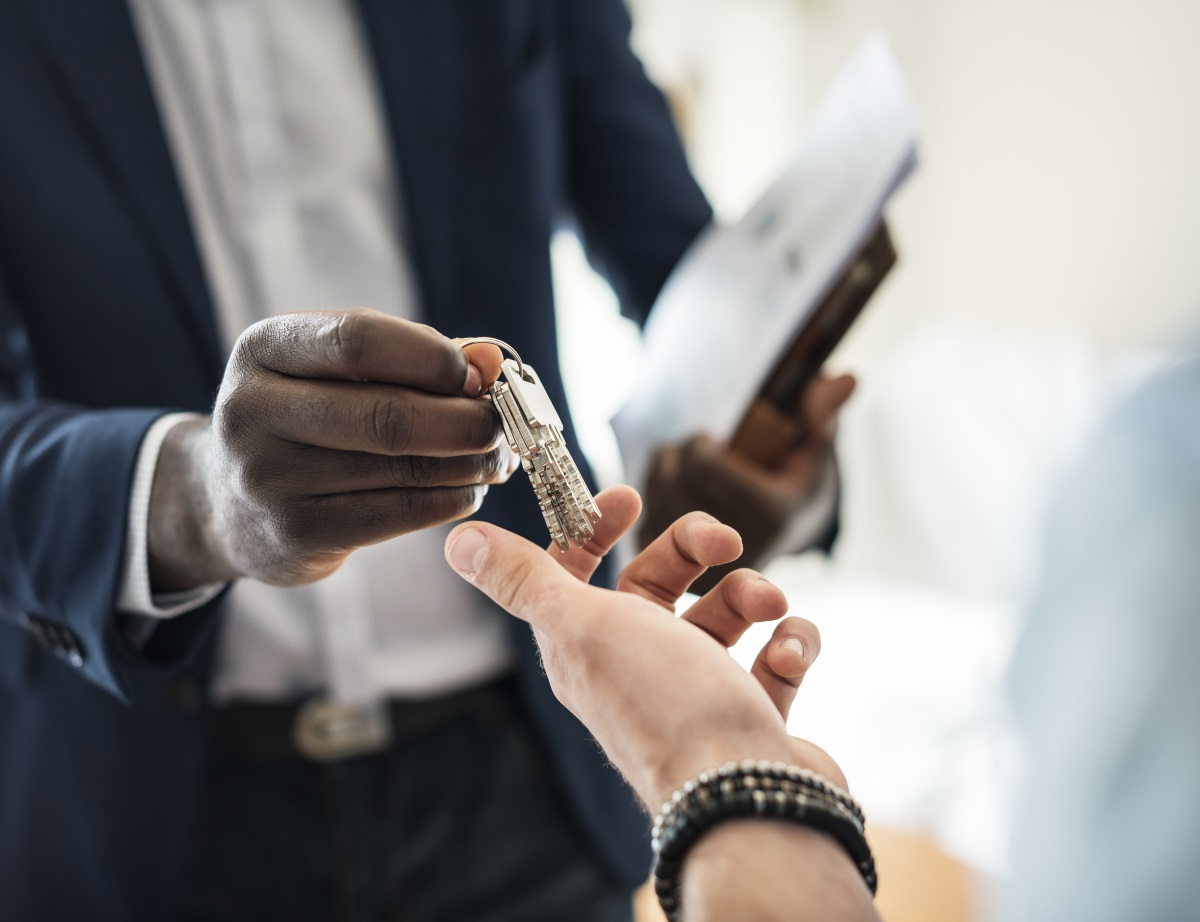 Agent immobilier donnant des clefs à quelqu'un. 