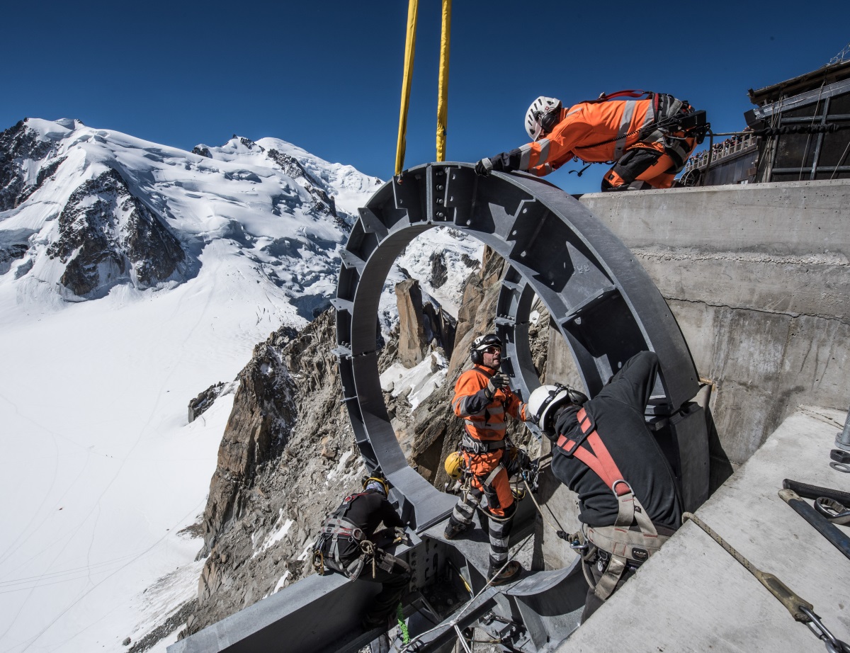 Des hommes travaillent en haute montagne à la construction de l'aiguille du Midi